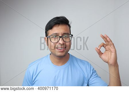 A Young Indian Man In Spectacles Looking Towards The Camera And Smiling With Clean Teeth And Showing