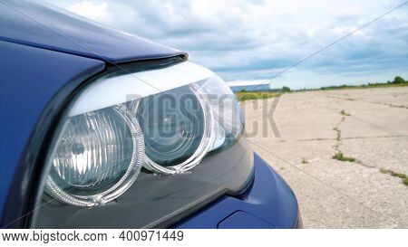Close - Up Of The Headlights Of A Blue Car. High Quality Photo