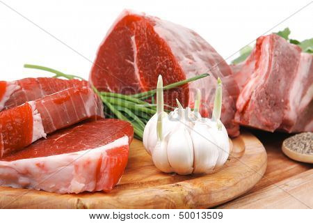 uncooked meat : raw fresh beef pork rib and fillet ready to cooking with garlic and green stuff over wood isolated on white background