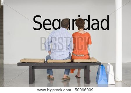 Rear view of couple reading Spanish text 