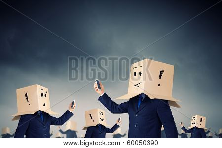 Businessman using mobile phone wearing carton box on head