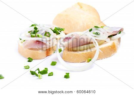 Sandwiches of white bread with herring onions and herbs on white