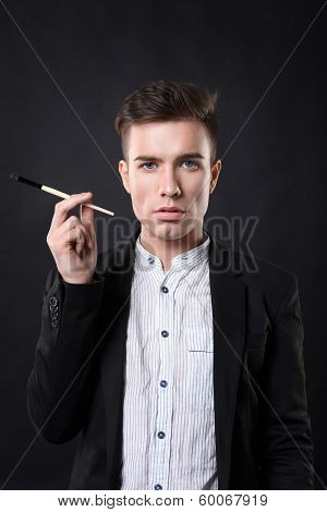 Stylish young handsome man in a suit with a brush.