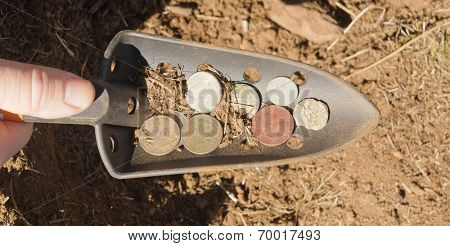 hand shovel with coins found metal detecting