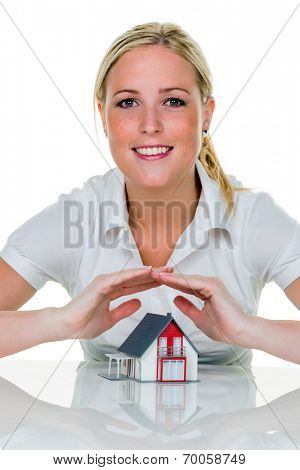 a woman protects with hands a haus.symbolfoto for insurance and building savings.
