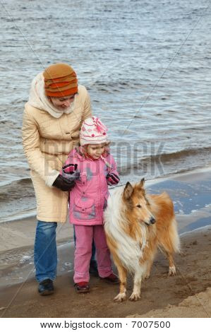 Gang i fri luft. Lille pige med mor og hund gå på efteråret beach. Hund racen colley