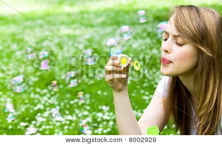 Dziewczyna dmuchanie baniek na zewnątrz