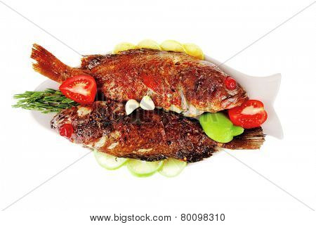 savory : roast golden fish served on fish plate with lemon tomatoes and rosemary