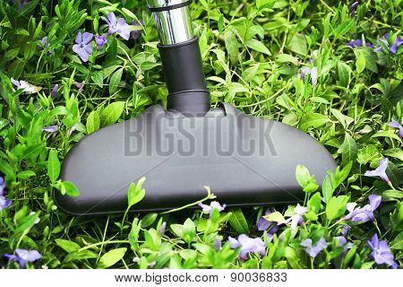 Metal pipe of vacuum cleaner in action - clean carpet of real green grass. Ecology concept 