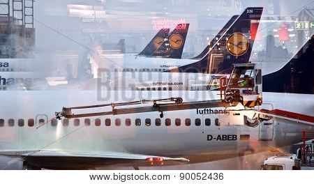 Worker Deices The Wing Of The Plain In Frankfurt Airport