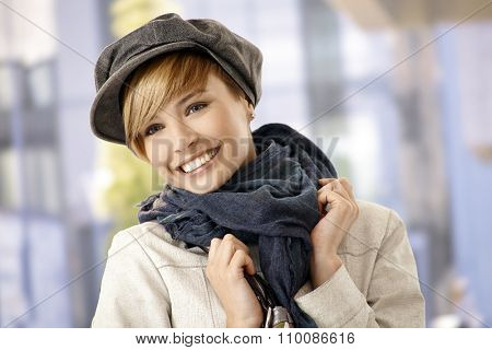 Outdoor portrait of attractive young woman in winter clothes, smiling.