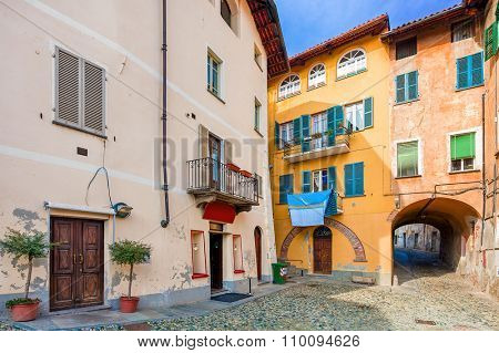 Small backstreet among between colorful houses in town of Saluzzo in Piedmont, Northern Italy.