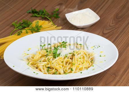 Spaghetti Aglio e Olio, an Italian recipe of pasta, in a wooden table.