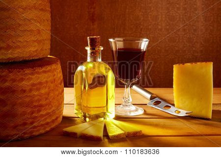 Manchego cheese from Spain with olive oil and red wine on wood