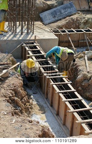 Group of construction workers fabricating ground beam steel reinforcement bar