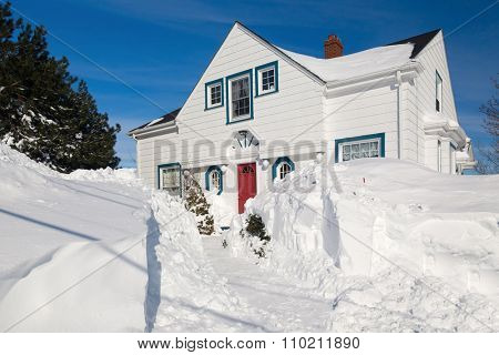 Traditional family home in a north American suburb buried with snow.