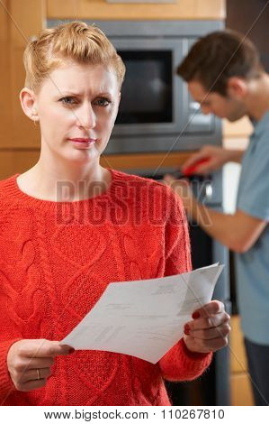 Worried Woman With Cooker Reapir Bill