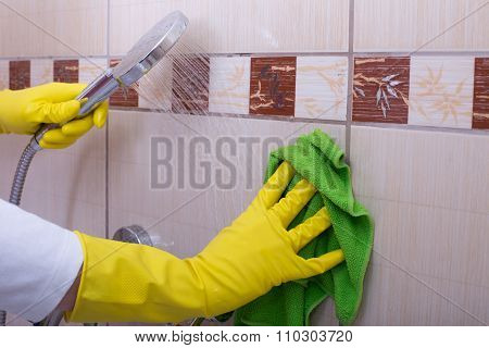 Woman Cleaning Tiles In Bathroom