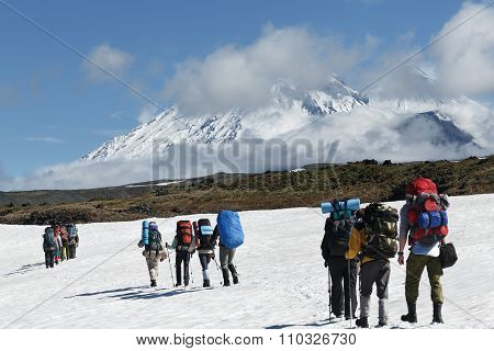 Hikers Group Trekking In Mountains On Background Of Volcanoes