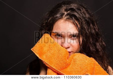 Beautiful sports girl with a towel on a dark background.