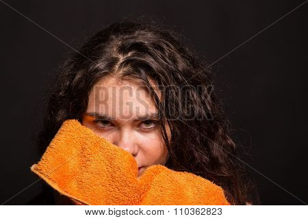 Beautiful sports girl with a towel on a dark background.