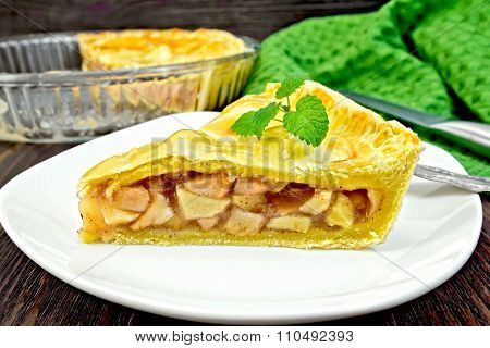 Pie apple with mint in plate on board