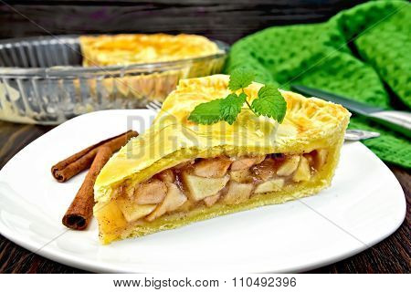 Pie apple with mint in plate on dark board