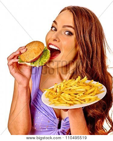 Girl eating hamburger and fried potatoes. Fastfood concept.