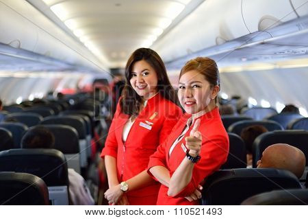 SINGAPORE - NOVEMBER 04, 2015: AirAsia crew members on board of Airbus A320. AirAsia is a Malaysian low-cost airline headquartered near Kuala Lumpur, Malaysia