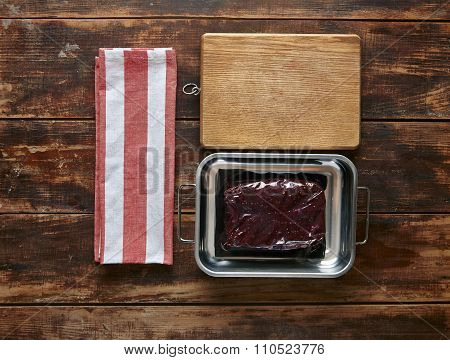 Vacuum Pack Of Whale Meat Steak Metal Pot With Towel And Wooden Plate