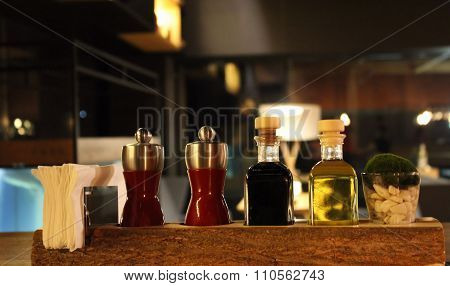 Olive oil, balsamic vinegar, garlic and herbs in table seasoning set at the restaurant