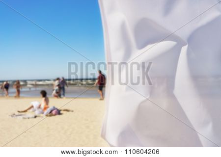 White Flag On The Beach Of The Baltic Sea In The Wind. Blurry