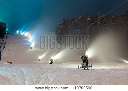 snow cannons working at night in the mountains