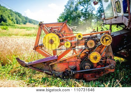 Detail Of Harvester Machinery, Tractor At Farm With Combine Collecting mature crops
