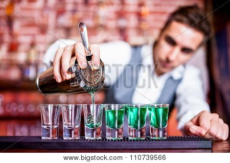 Bartender Pouring Blue Curacao Alcoholic Cocktail In Glasses On bar