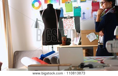 Beautiful fashion designer standing in studio