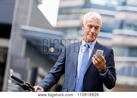 Portrait of confident businessman with his mobile phone outdoors