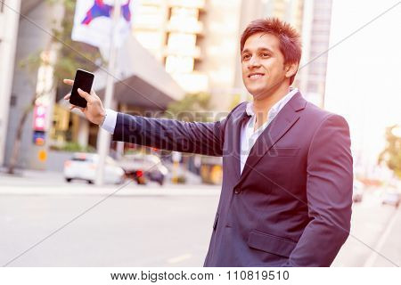 Portrait of confident businessman with his mobile phone outdoors
