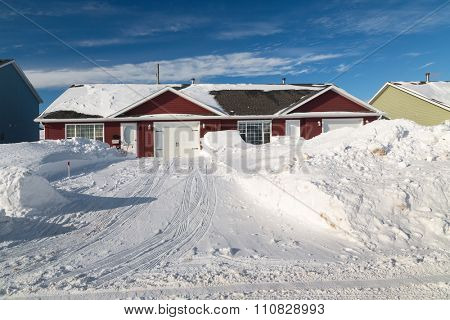 Snow piled up along a plowed road in a northern suburb.