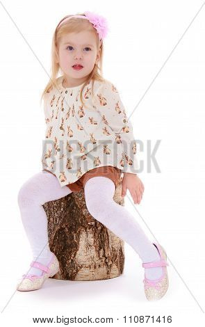 little girl sat down on a stump
