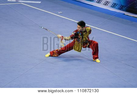 JAKARTA, INDONESIA, NOVEMBER 14, 2015: Jason Chen-Leung from Canada performs the movements in the men's Jianshu (sword) event at the 13th World Wushu Championship 2015 held in Istora Senayan, Jakarta.