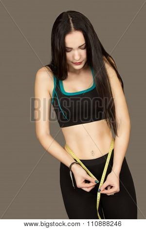 The Beautiful Young Woman Measures In Sportswear To Herself Waist Volume