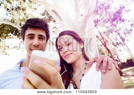 Young couple in the park making their selfi with mobile phone