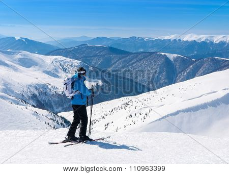 Skier In Alpine Skis Go Skiing In Snowy Mountains Landscape