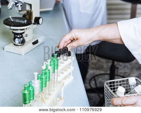 Laboratory Assistant Puts Test Tubes.