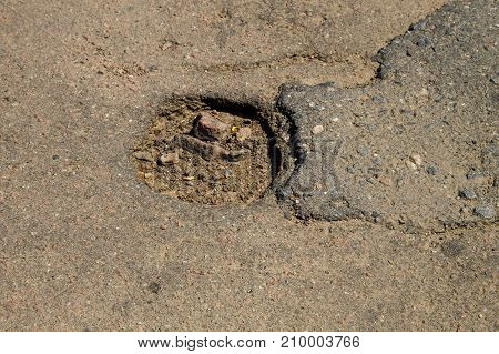 Close-up of damaged asphalt road with pothole