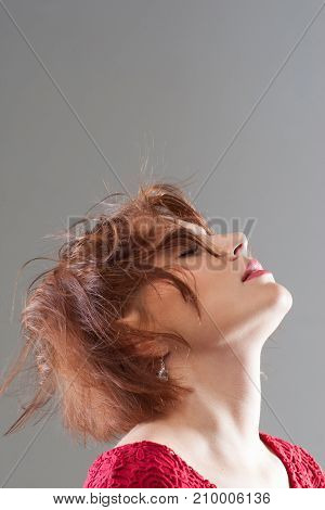 Feeling of freedom and pleasure. Female hairstyle advertising. Creative woman haircut closeup on grey background with free space, pleasant concept