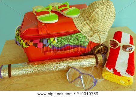 Suitcase with things for spending summer vacation. Anticipation of voyage. Women's clothes and accessories in red suitcase - Retro color