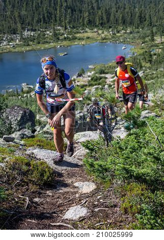 ERGAKI, RUSSIA - AUGUST 05 2017: Several athletes run through the mountains, participants trailing the SKAYRANFEST competition on August 5, 2017 in the Ergaki National Park, Russia