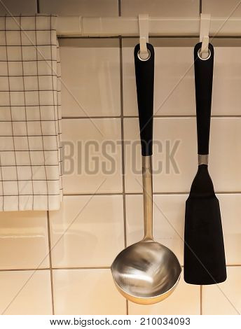 Kitchen Equipment Flippers and Ladles Hanging on The Wall Kitchen Utensil for Frying and Cooking Meal.